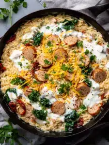 Creamy chicken sausage orzo dish in a skillet
